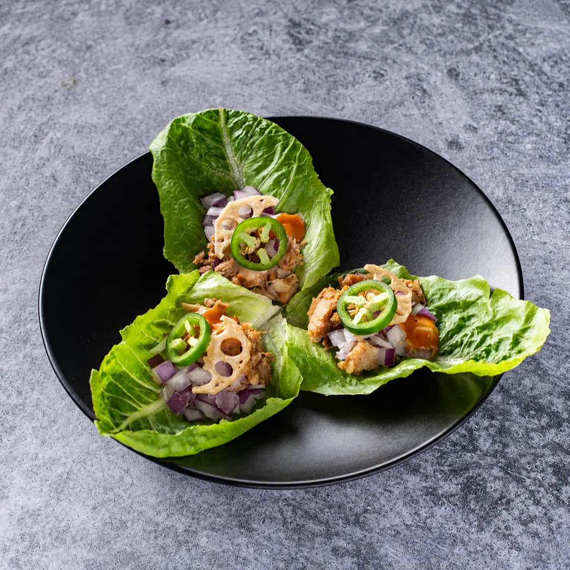 Chashu Lettuce Wrap - Diced pork chashu wrapped in romaine leaves with savory-spicy red miso, red onion, jalapeño, and fried lotus root