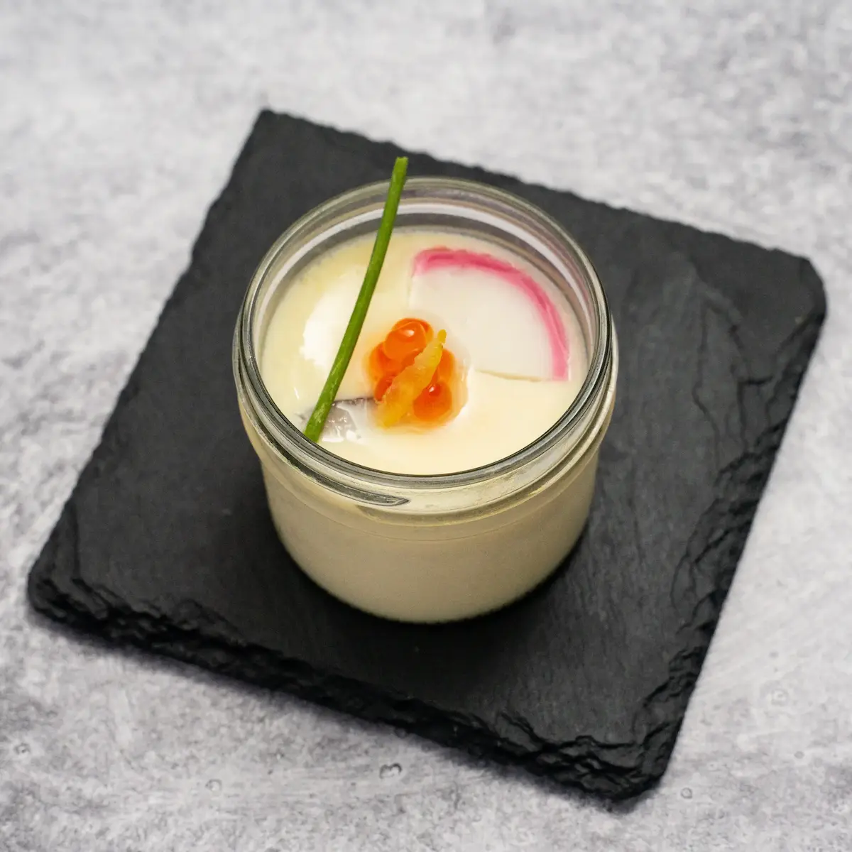 Chawanmushi - Silky Japanese savory egg custard steamed with chicken, edamame, shiitake mushrooms, kamaboko fish cake, salmon roe, chive, and yuzu zest