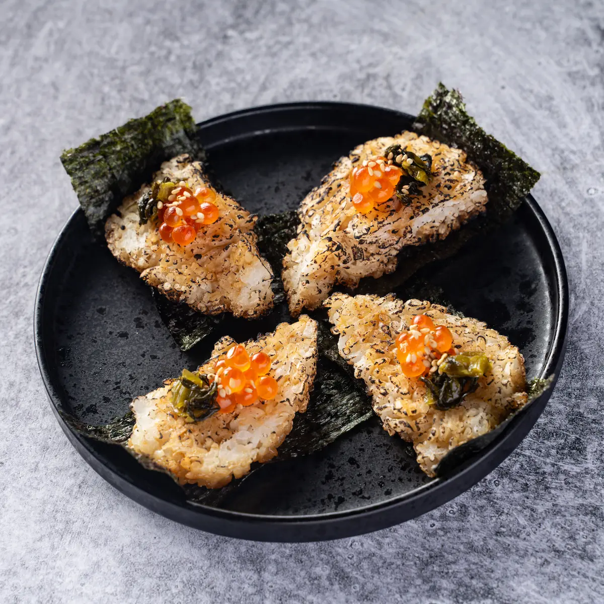 Ikura Yaki Onigiri - Soy-glazed grilled rice bites topped with ikura salmon roe, pickled takana greens, and nori, served in 4 pieces